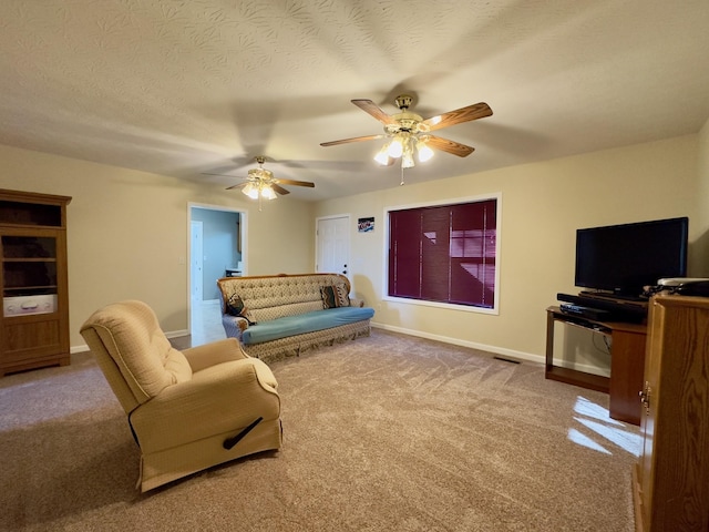 carpeted living room with ceiling fan and a textured ceiling