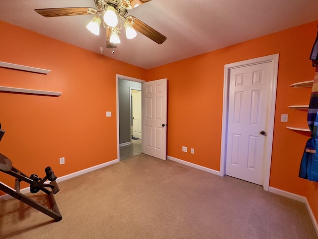 workout room featuring ceiling fan and carpet floors