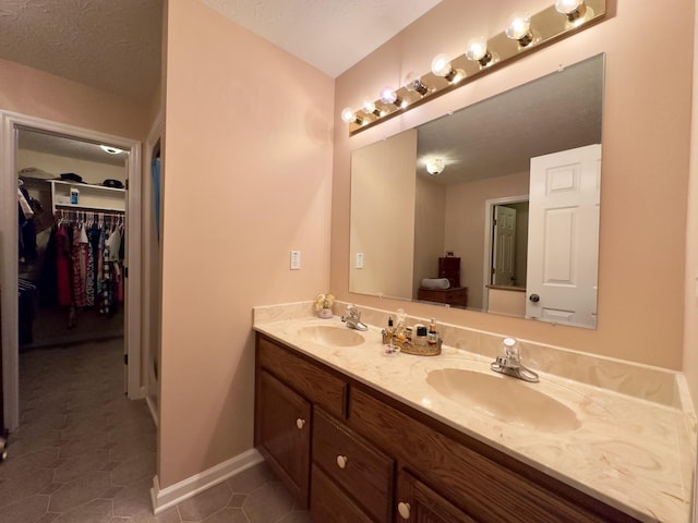 bathroom featuring tile patterned flooring, vanity, and a textured ceiling