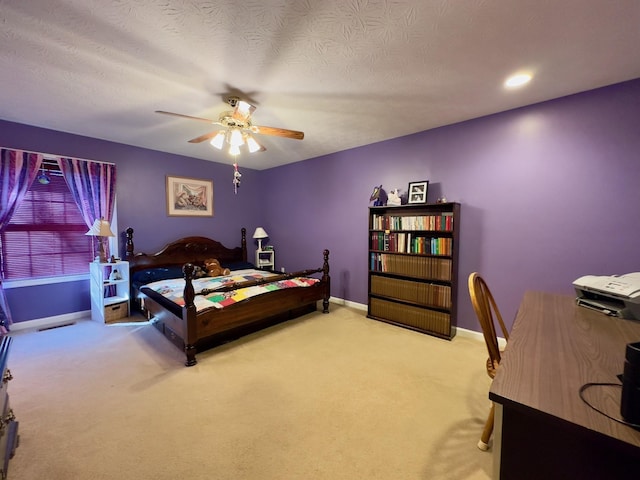 bedroom with ceiling fan, light carpet, and a textured ceiling