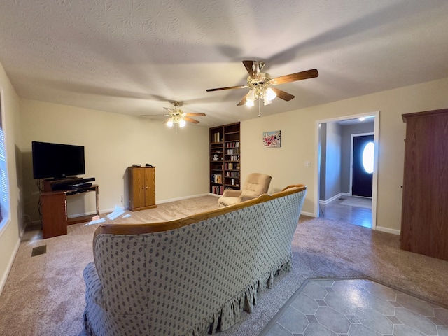 living room featuring carpet, a textured ceiling, and ceiling fan