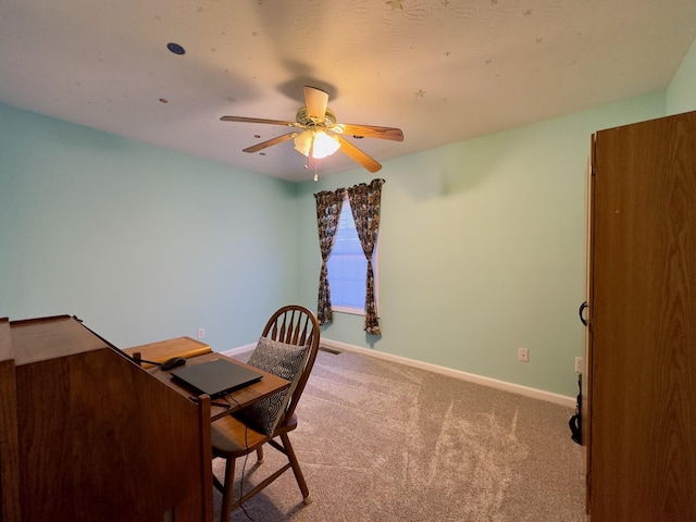 unfurnished office featuring ceiling fan and carpet floors