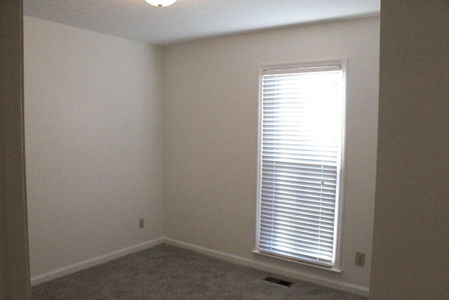 empty room featuring dark colored carpet