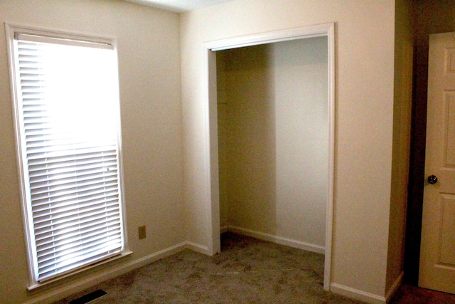 unfurnished bedroom featuring carpet flooring and a closet