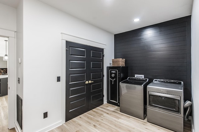 laundry area featuring washing machine and dryer and light hardwood / wood-style floors