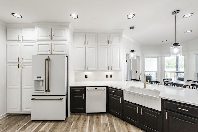 kitchen with white appliances, white cabinetry, decorative light fixtures, and sink