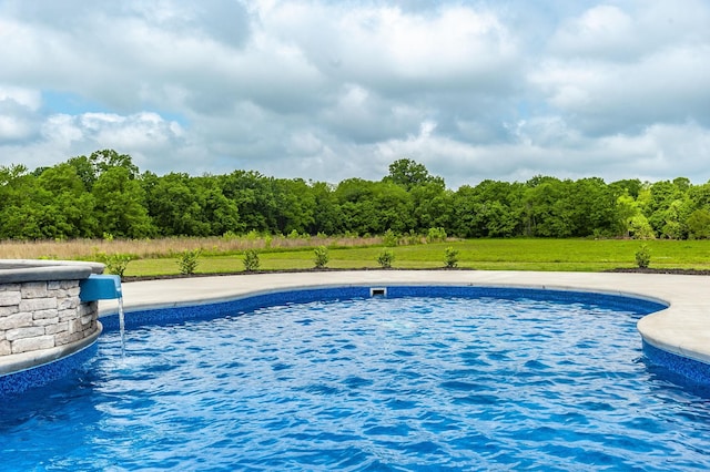 view of swimming pool with a yard