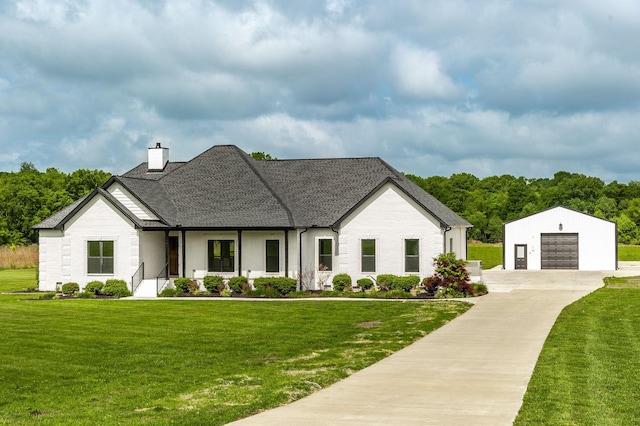 view of front facade with a porch, a front yard, a garage, and an outdoor structure