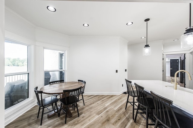 dining room with hardwood / wood-style flooring and crown molding