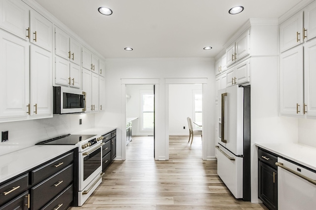 kitchen featuring white appliances, light wood-type flooring, white cabinets, and crown molding