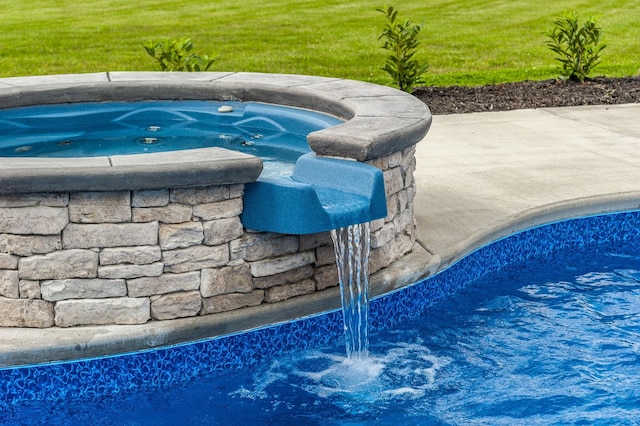 view of swimming pool with an outdoor hot tub