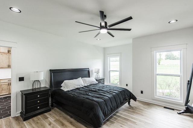 bedroom with ceiling fan and light wood-type flooring