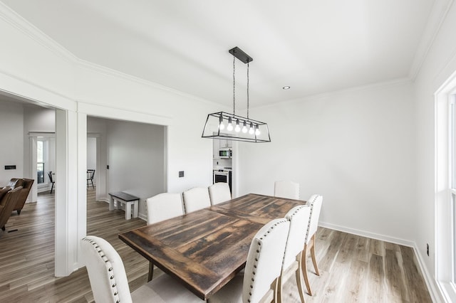 dining area featuring ornamental molding and wood-type flooring