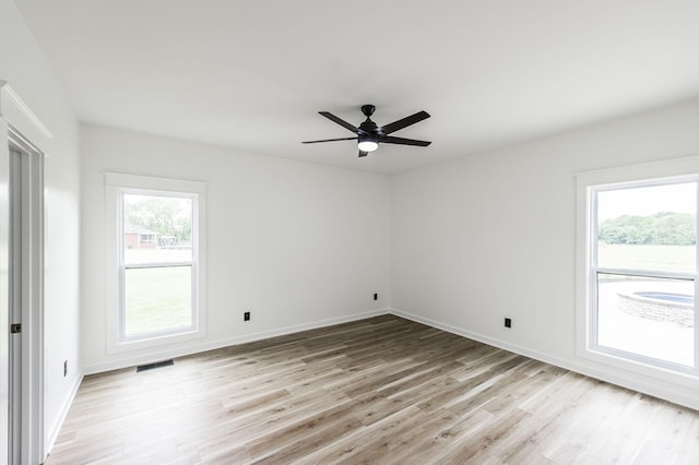 unfurnished room featuring ceiling fan, light wood-type flooring, and plenty of natural light