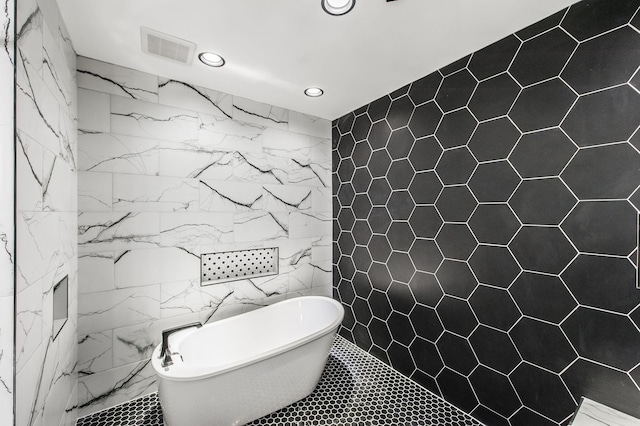 bathroom with tile walls and a bath