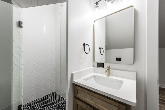 bathroom with tiled shower and vanity