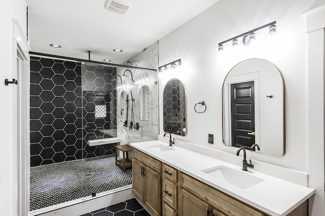 bathroom featuring vanity, tile patterned flooring, and tiled shower