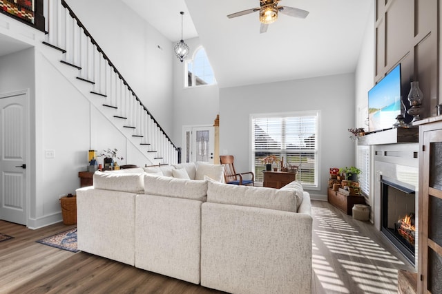 living room featuring ceiling fan, dark wood-type flooring, and a high ceiling