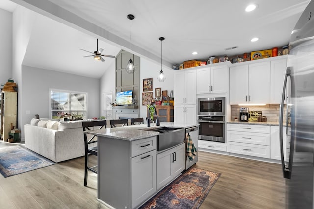 kitchen with a center island with sink, sink, white cabinetry, and stainless steel appliances