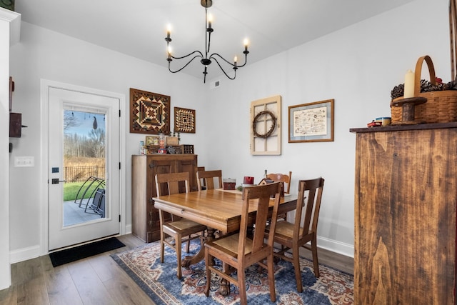 dining area featuring wood-type flooring and an inviting chandelier