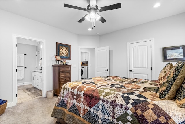 bedroom with ceiling fan, light colored carpet, ensuite bathroom, and washer / clothes dryer