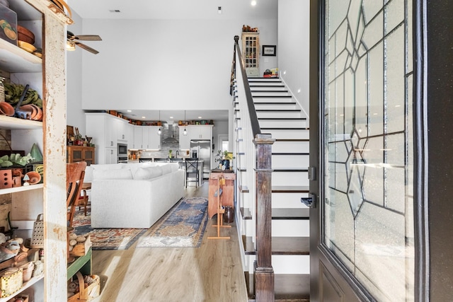 staircase with ceiling fan and hardwood / wood-style flooring