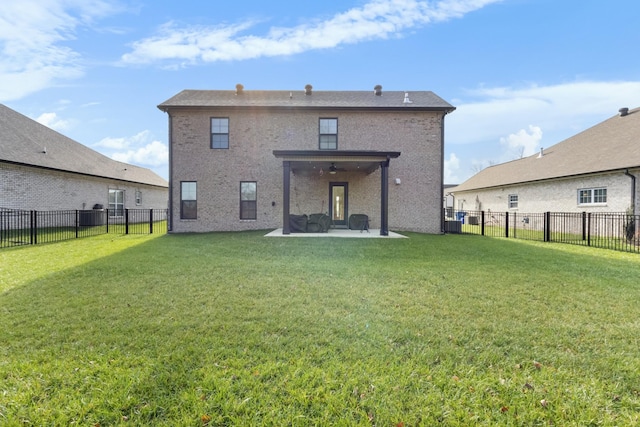 rear view of property featuring ceiling fan, a patio area, and a lawn