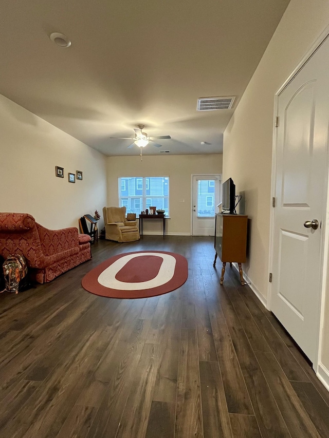 unfurnished living room featuring ceiling fan and dark hardwood / wood-style flooring