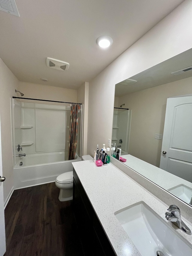 full bathroom featuring hardwood / wood-style floors, vanity, shower / tub combo, and toilet