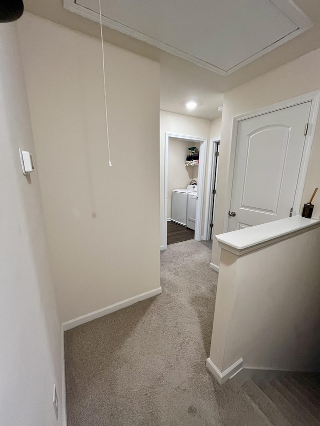 hall with washer and clothes dryer and carpet