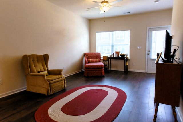 sitting room with baseboards, ceiling fan, and wood finished floors