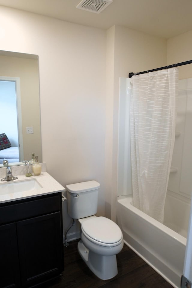 full bathroom with vanity, wood finished floors, visible vents, shower / bath combo, and toilet
