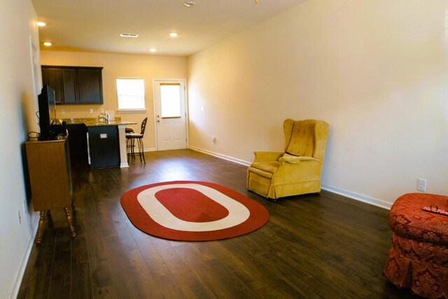 living area with recessed lighting, visible vents, baseboards, and dark wood-style floors