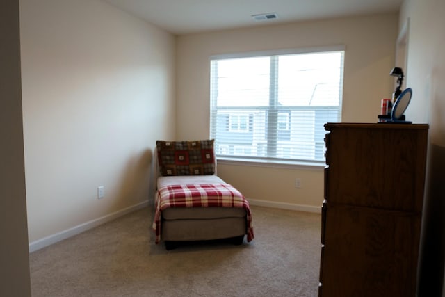 living area with visible vents, baseboards, and carpet