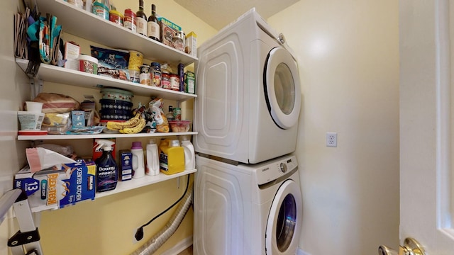 clothes washing area with stacked washer and clothes dryer