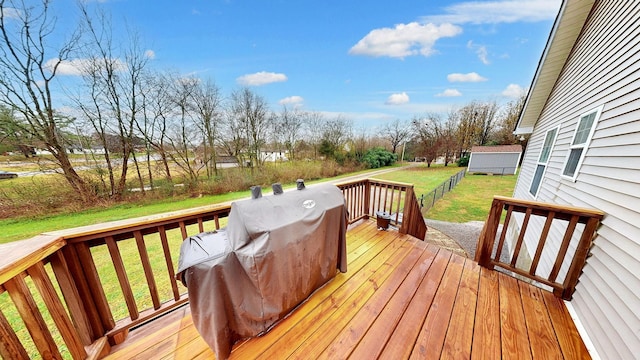 wooden terrace with a grill and a yard