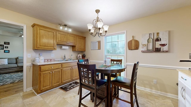 dining room featuring light tile patterned floors, ceiling fan with notable chandelier, and sink