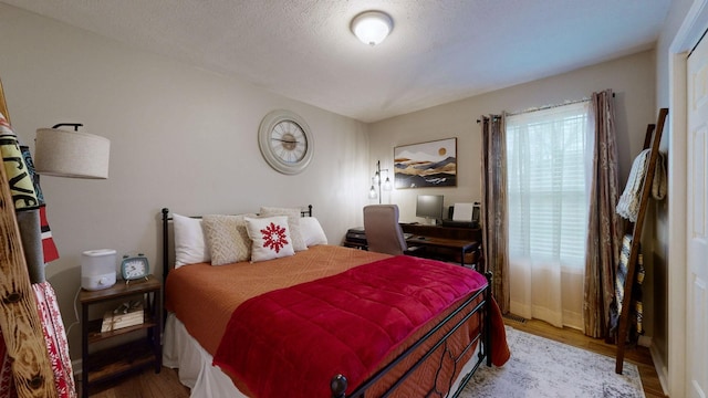 bedroom with light hardwood / wood-style floors and a textured ceiling