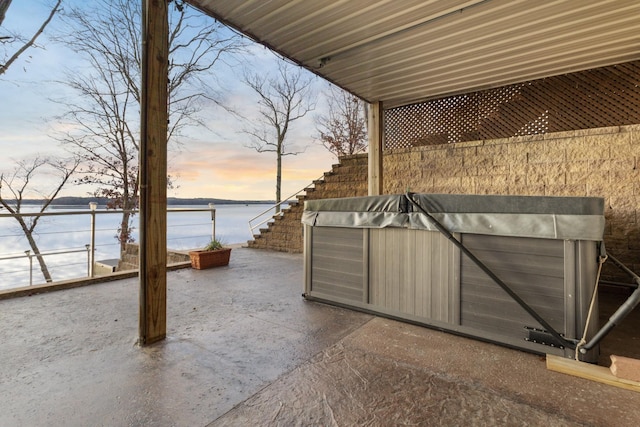 patio terrace at dusk featuring a water view