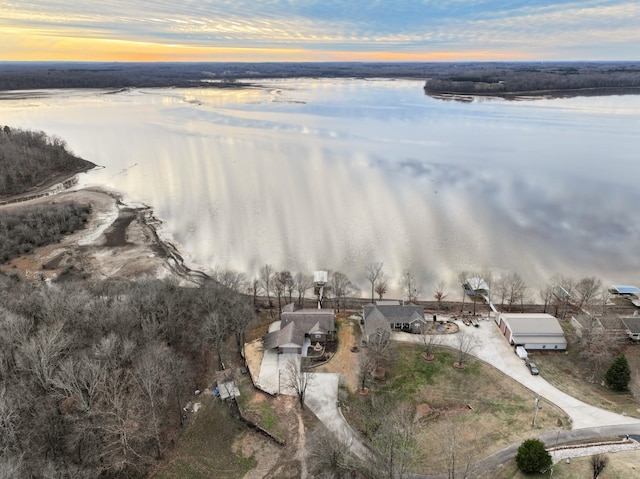 aerial view at dusk featuring a water view