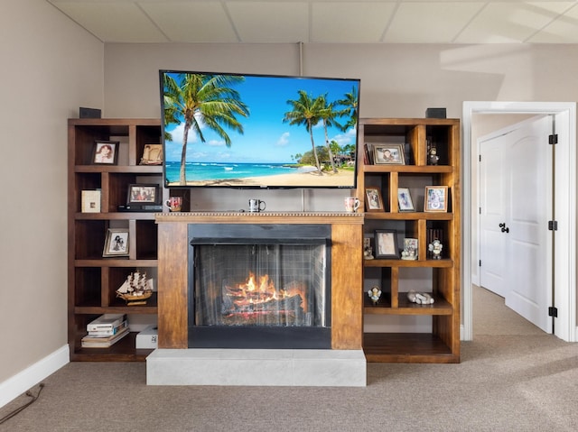 carpeted living room with a drop ceiling