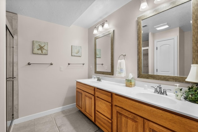 bathroom with vanity, a textured ceiling, tile patterned floors, and a shower with shower door