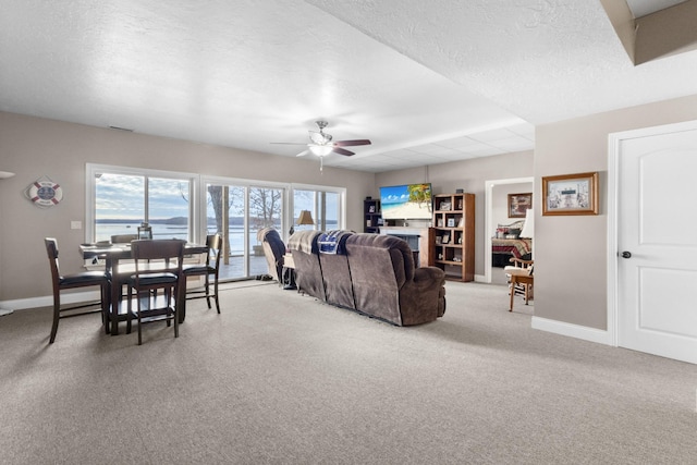 carpeted living room featuring a textured ceiling and ceiling fan