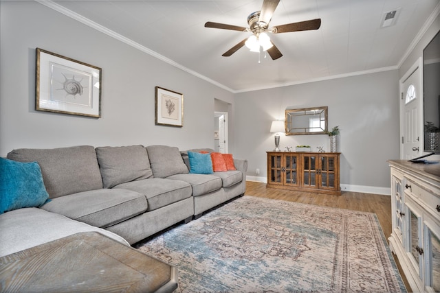 living room with ceiling fan, ornamental molding, and light wood-type flooring