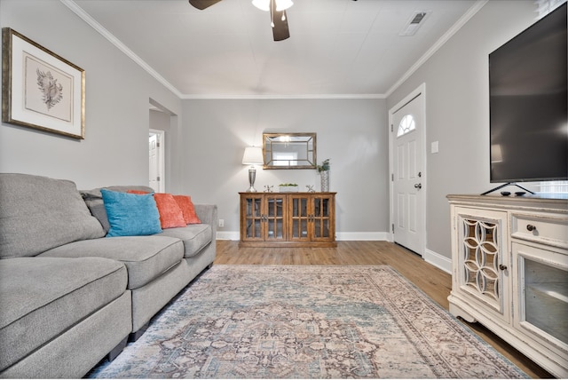 living room featuring light wood-type flooring, ceiling fan, and crown molding