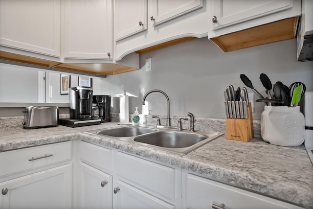 kitchen featuring white cabinetry and sink