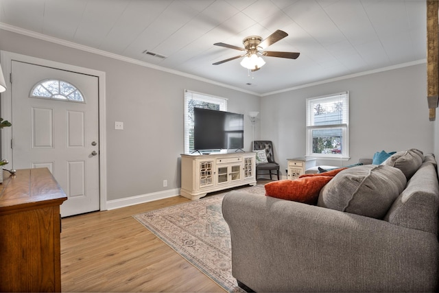 living room with plenty of natural light, ornamental molding, and light hardwood / wood-style flooring