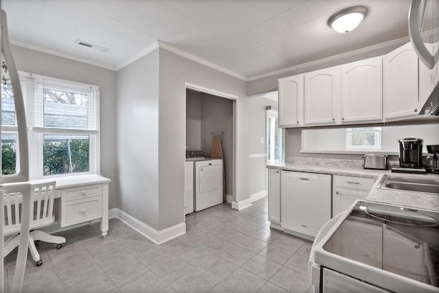 kitchen with white cabinets, stove, white dishwasher, and independent washer and dryer