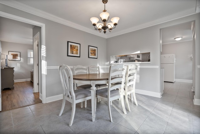 dining space with light tile patterned floors, an inviting chandelier, and ornamental molding