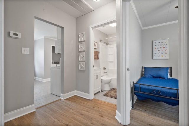 corridor with washer / dryer, light hardwood / wood-style flooring, and crown molding